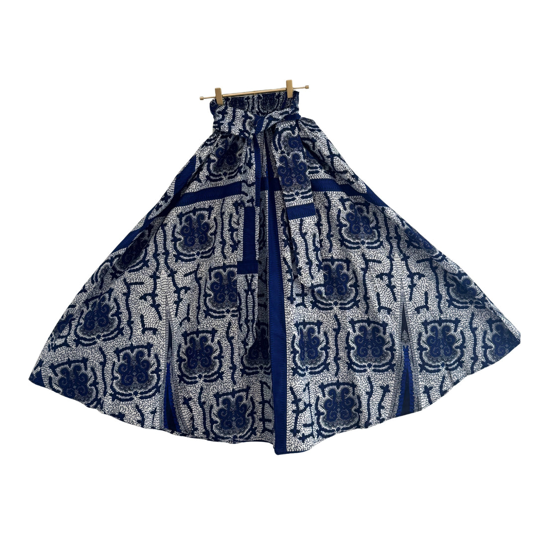 Blue and white patterned skirt on a hanger against a white background